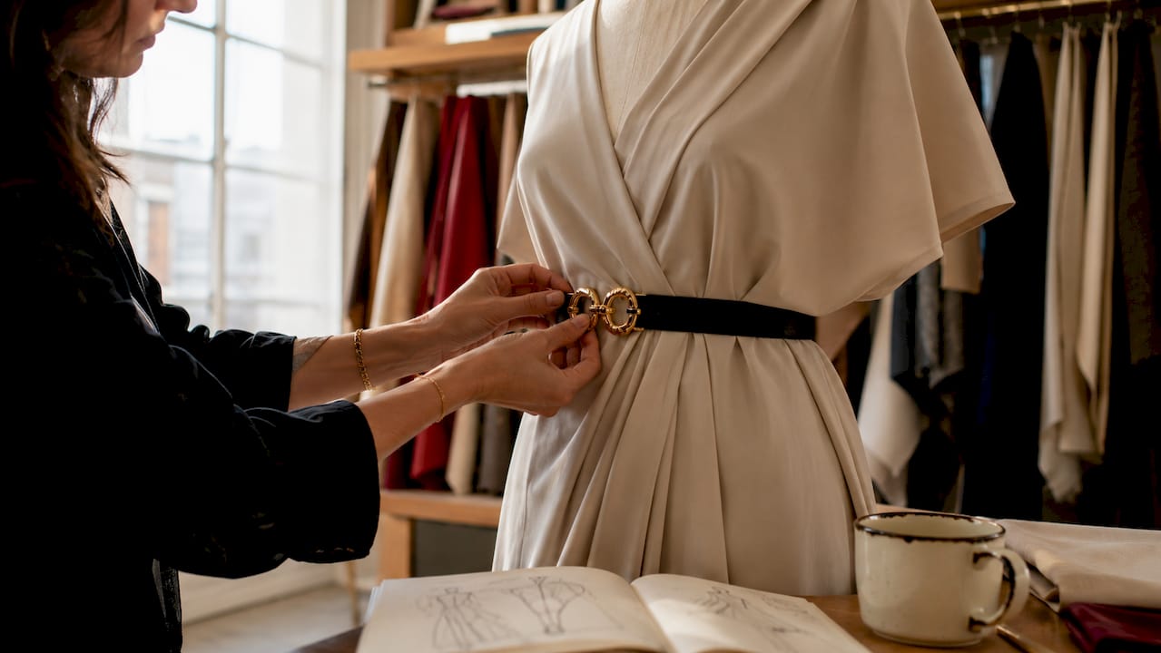 Des mains en train de régler une ceinture sur un mannequin
