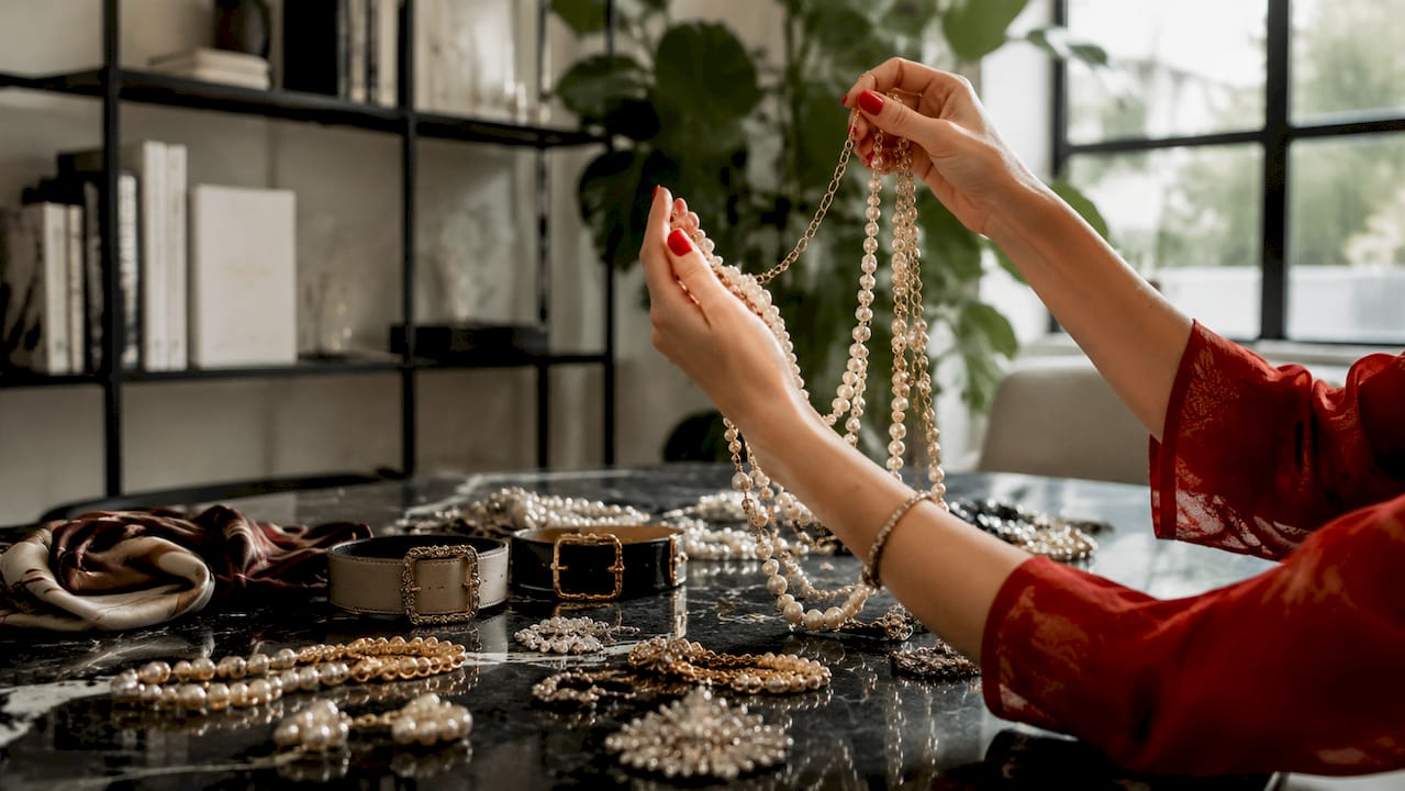 Manos acomodando pulseras en capas sobre una mesa