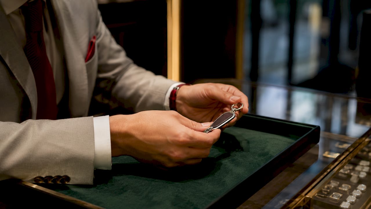 Изящные руки с браслетом Cartier на фоне мягкого серого оттенка.