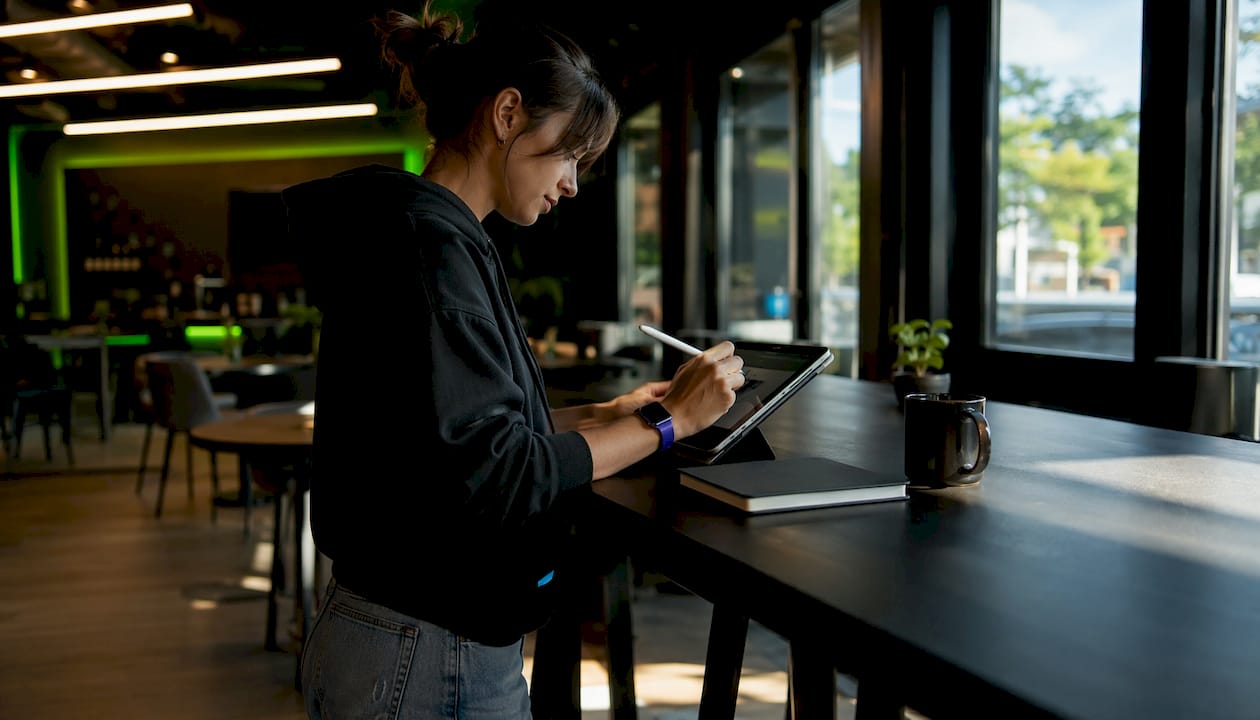 Des mains s'activent sur un clavier d’ordinateur, entourées de notes sur les indicateurs clés de performance.