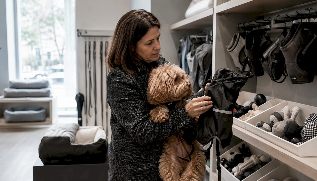 En kunde kigger nærmere på en hundejakke i dyrebutikken.