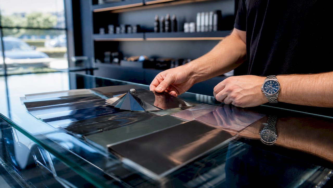 Hands choosing window tint film swatches