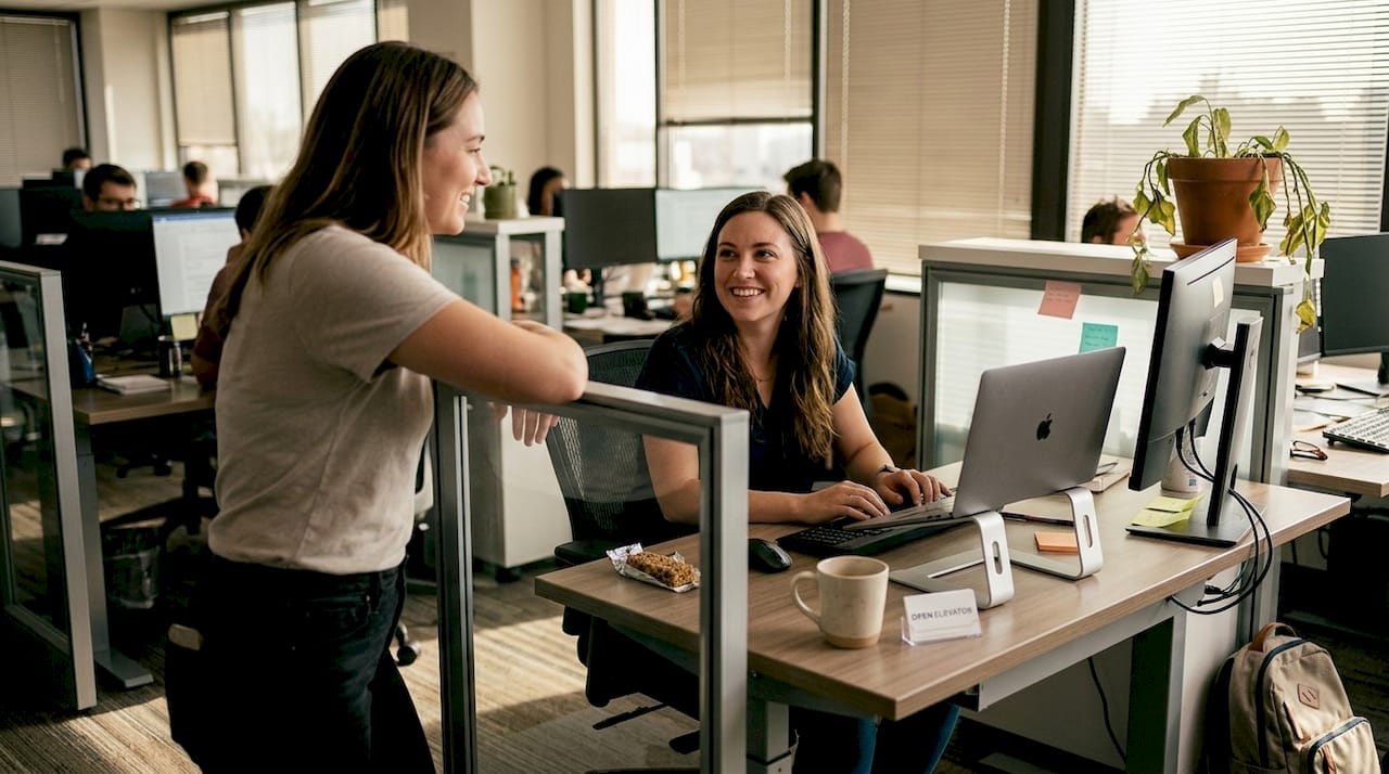 Supervisor recognizes team member at desk