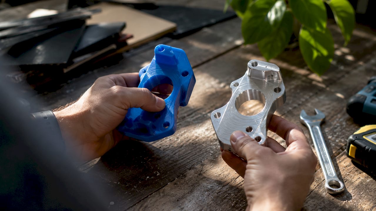 Hands comparing prototype materials in workshop