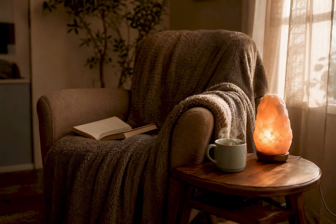 Cozy corner with tea and candle, symbolizing comfort
