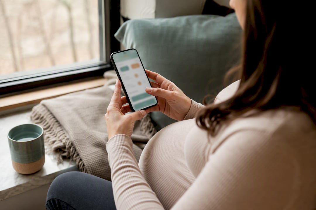 Pregnant person tracking symptoms on phone