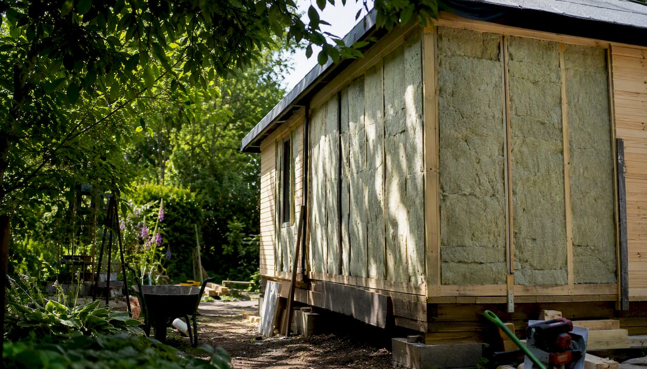 Garden building with visible insulation panels in UK garden