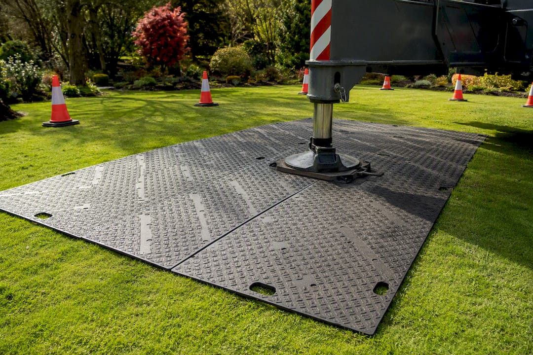 Ground protection mats laid for crane delivery in garden