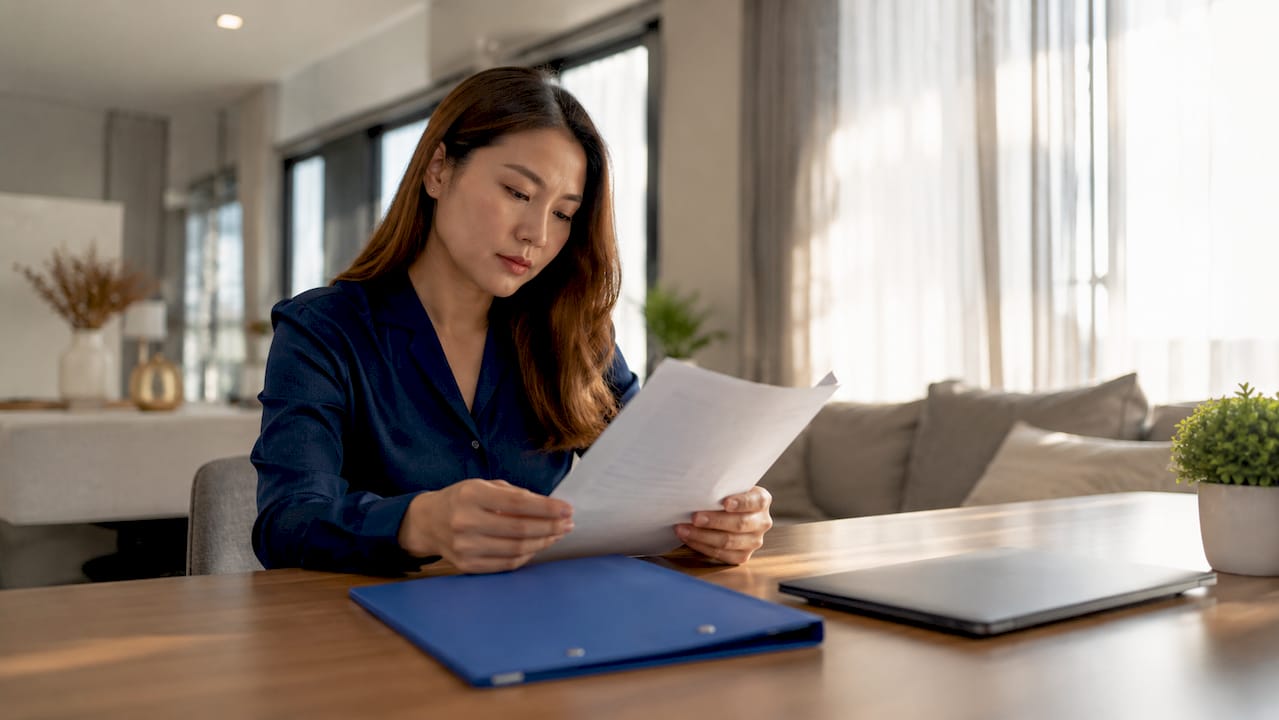 Filipino woman reviewing medical certificate at desk