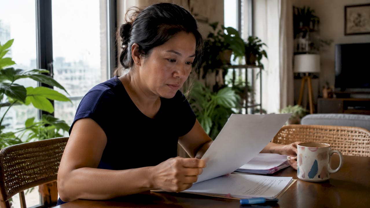 Filipino expat reviewing notarized Philippine document at desk