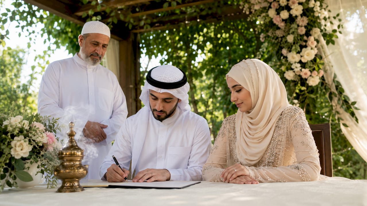 Muslim couple signing Nikah contract indoors