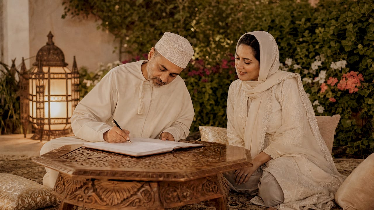 Muslim couple signing Nikkah contract indoors