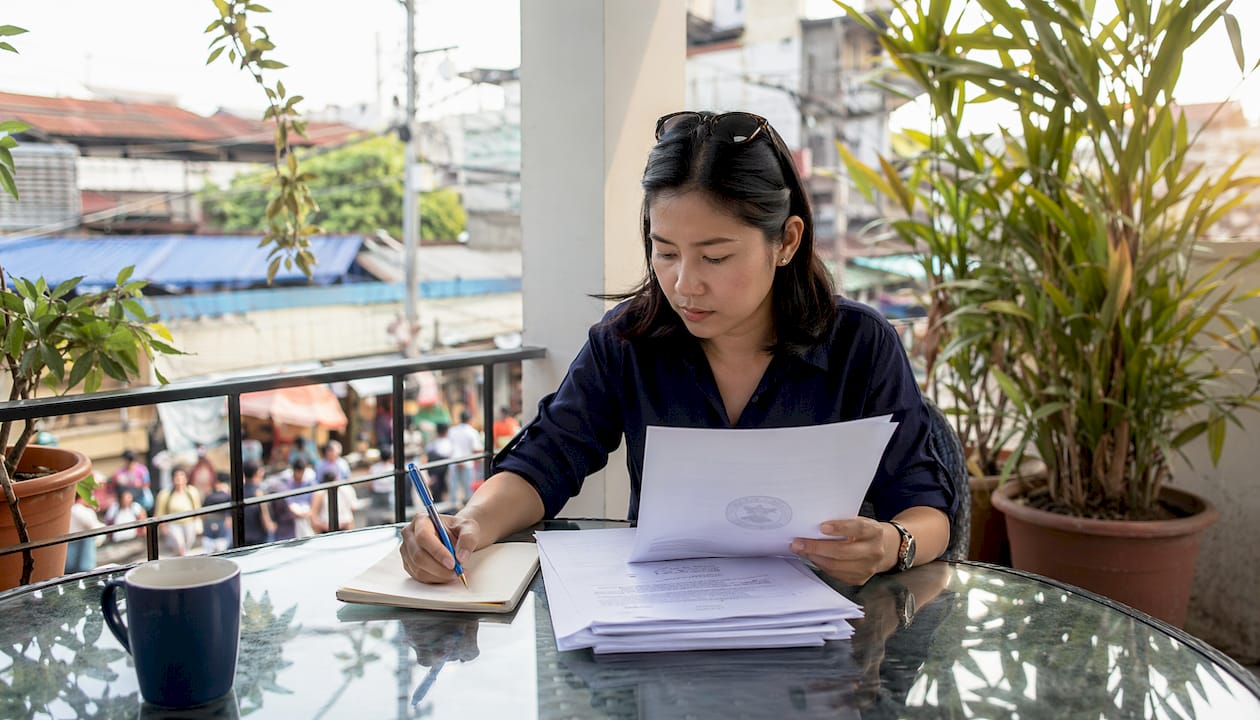 Filipino woman reviewing apostille documents at home