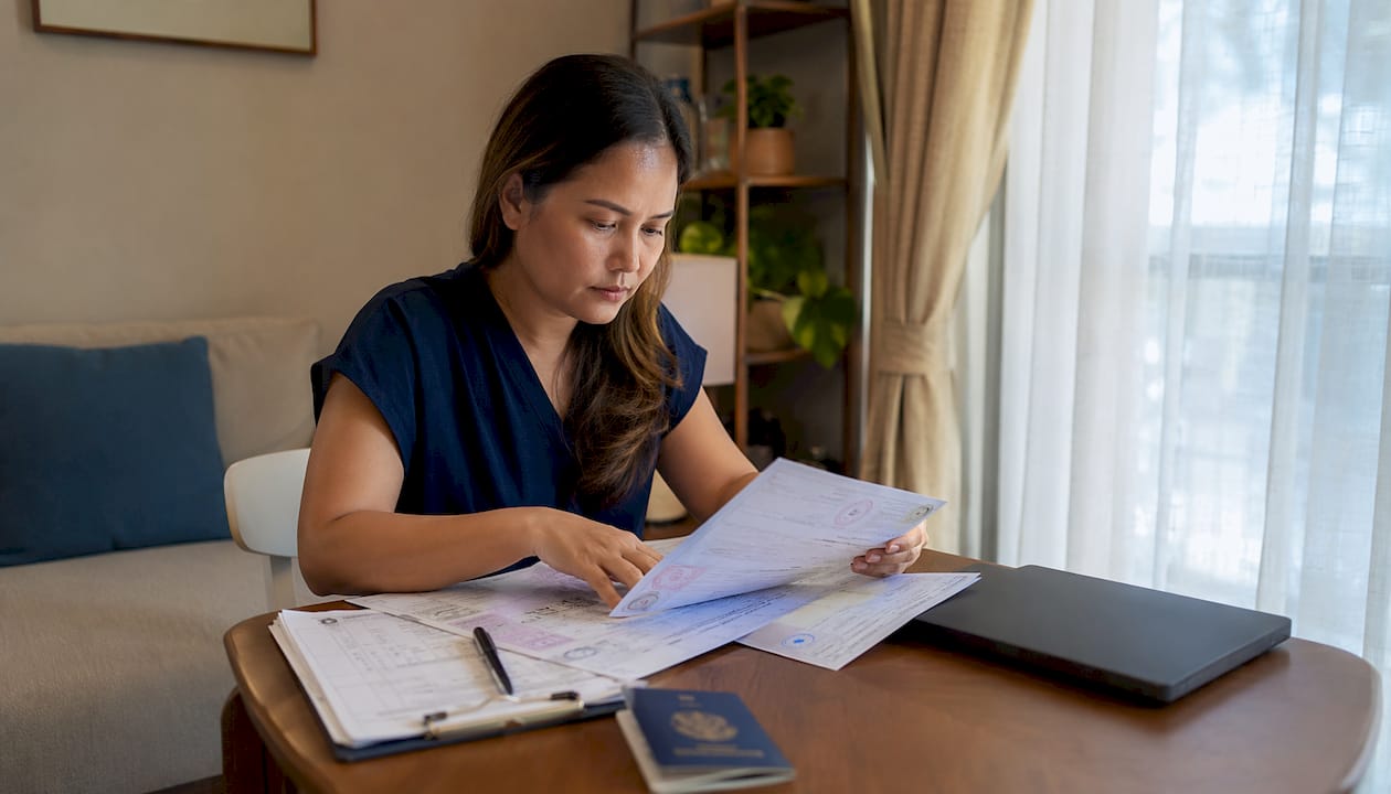 Filipino expat organizing documents at table
