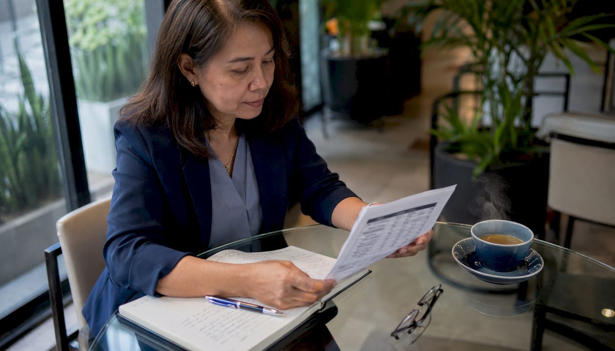 Woman reviewing attestation cost quote papers