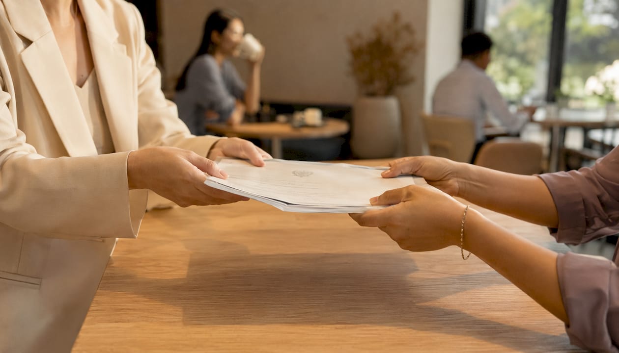 Hands exchanging official marriage certificate copies