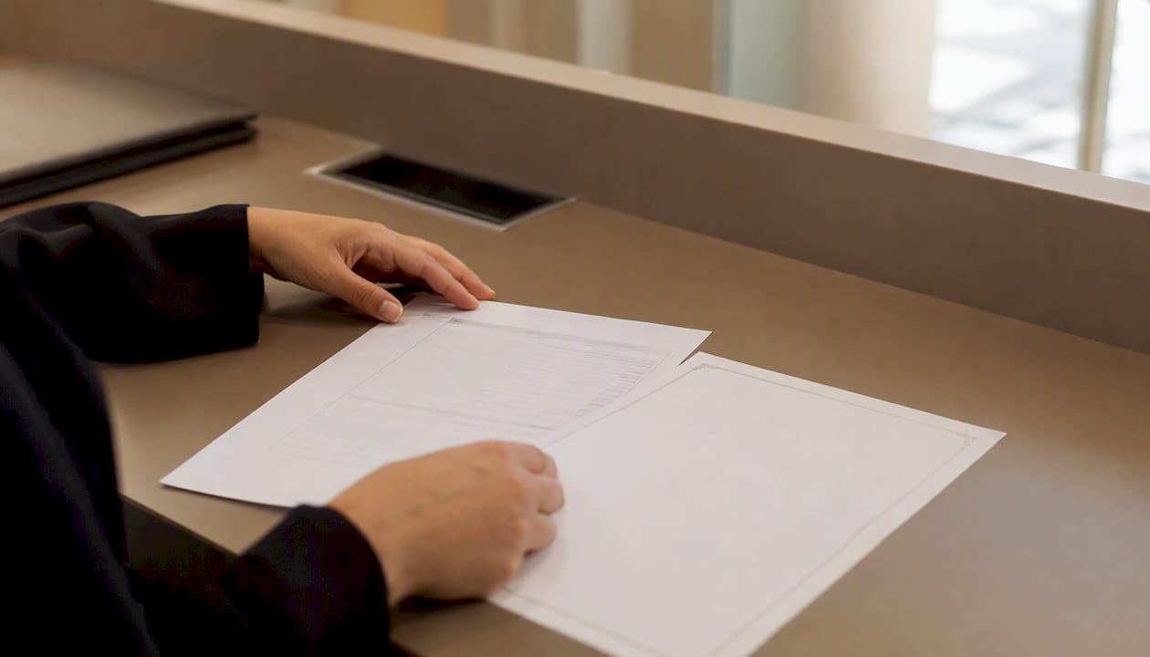 Hands holding Emirates ID update form and marriage certificate