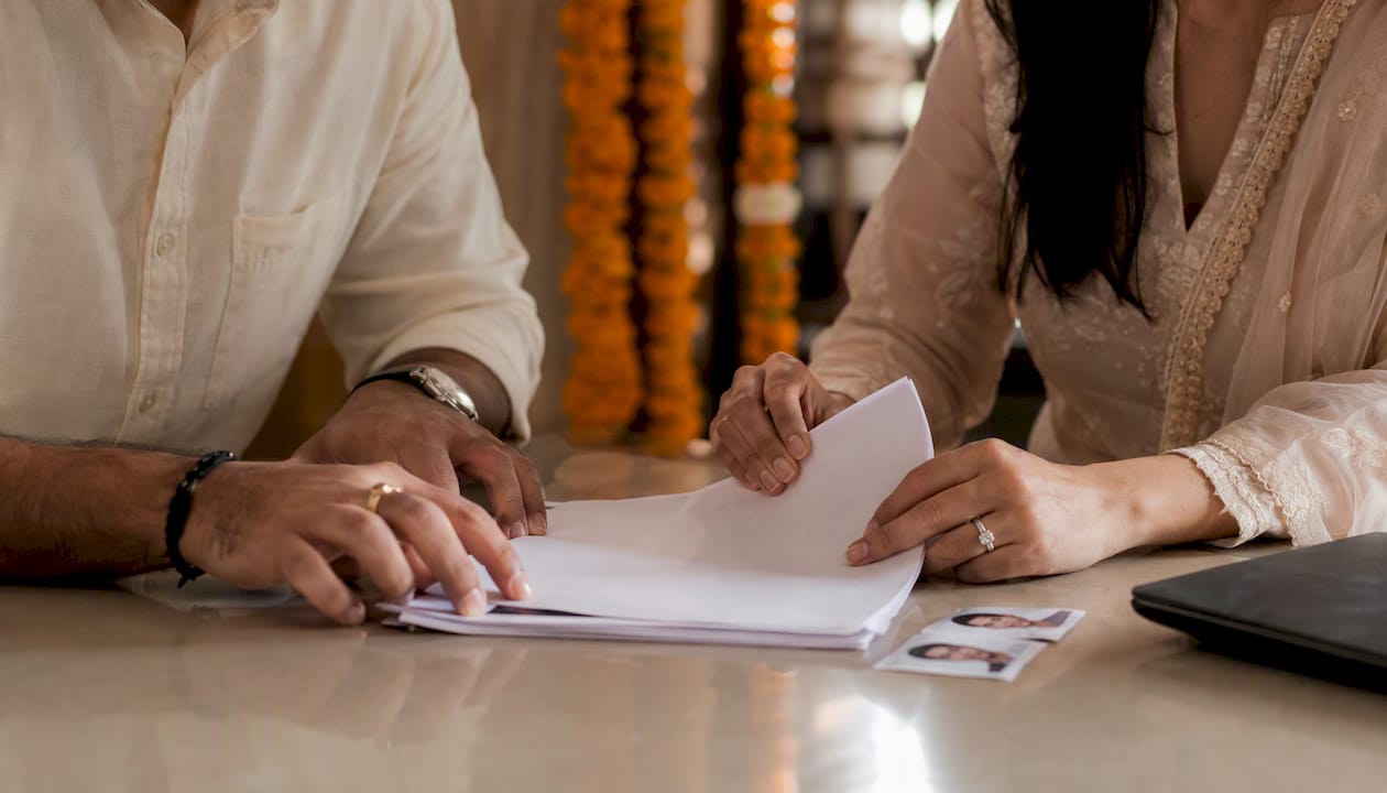 Hands organizing marriage affidavit and photos