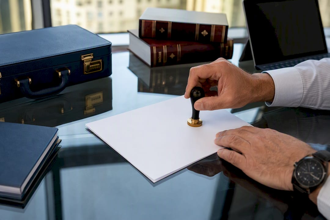 Hands stamping official document in attestation office
