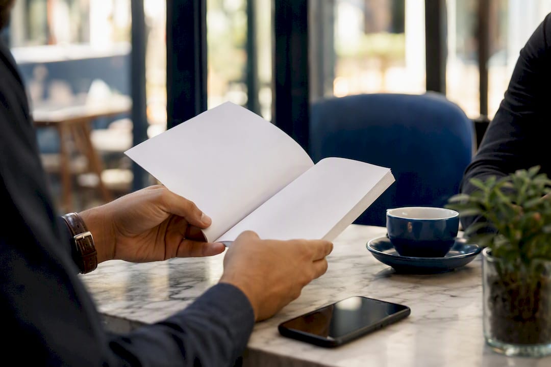 Hands holding document and phone side by side