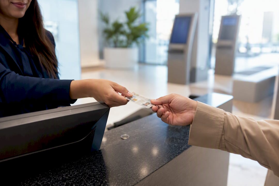 Hands holding Emirates ID card at service counter