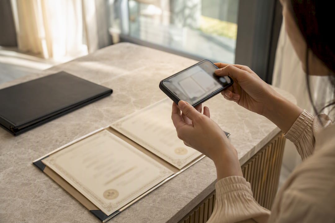 Hands photographing marriage certificate pages