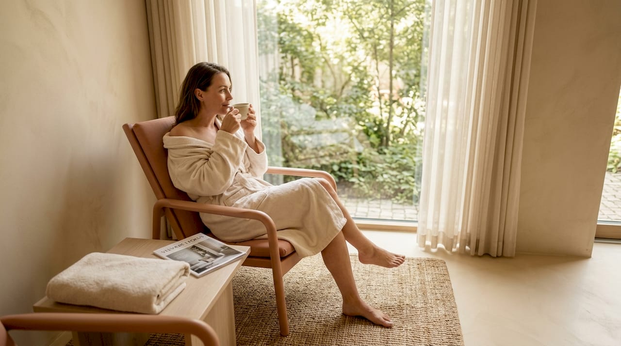 En kvinde nyder roen i en spa-lounge, mens hun slapper af med en kop te.