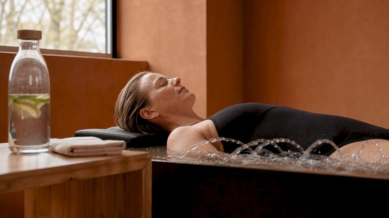 En kvinde nyder en afslappende hydromassage og lader sig forkæle i spaens rolige omgivelser.