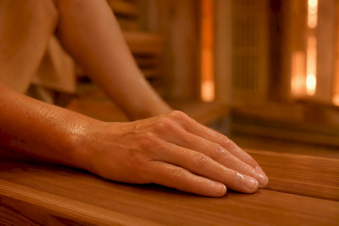 Nærbillede af underarm i infrarød sauna, hvor varmen hjælper med at løsne muskelspændinger.