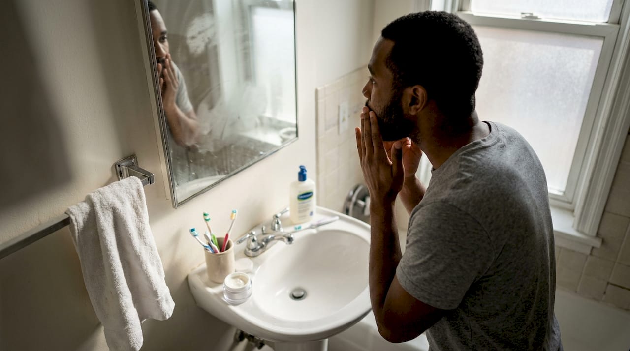 Man applying moisturizer after cleansing