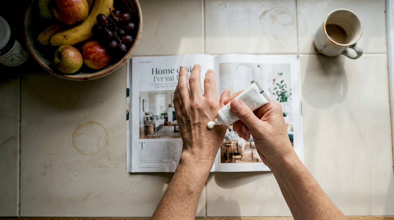 Hands applying cream on clean kitchen counter