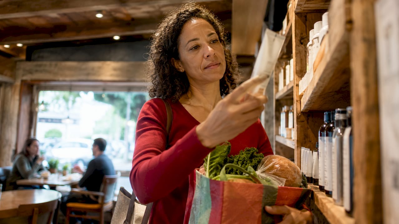 Woman examining toothpaste ingredient label in store