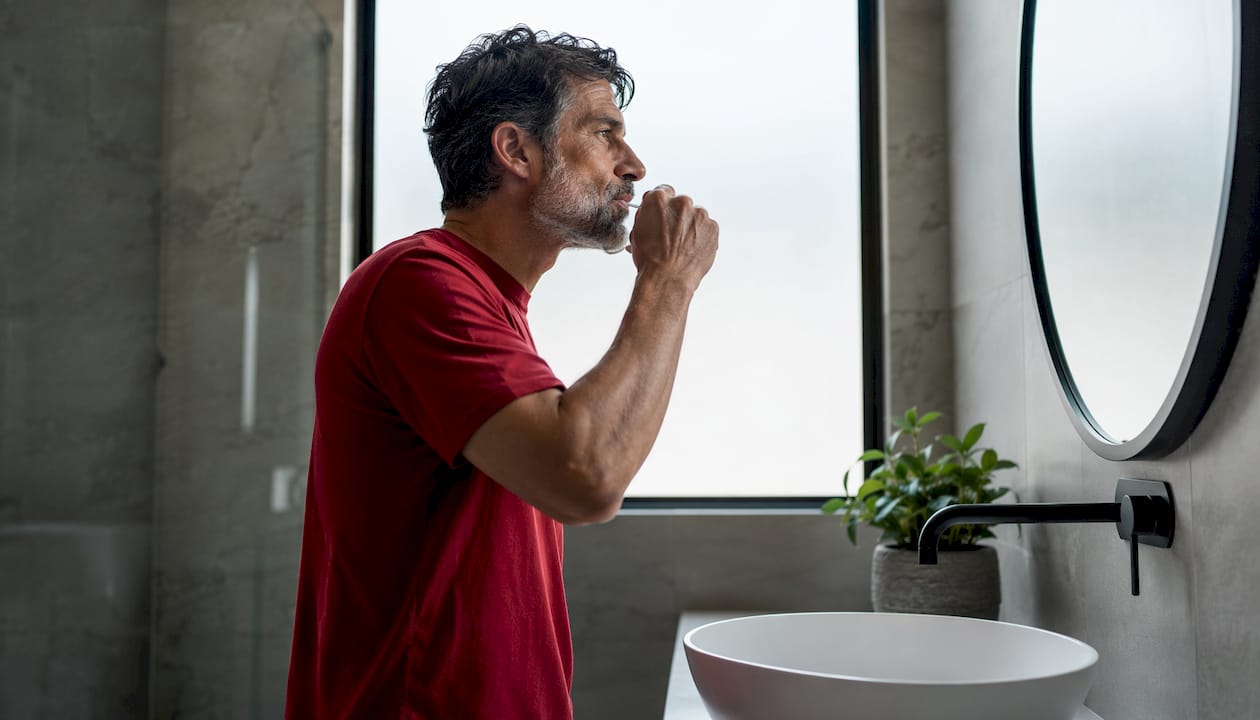 Man rinsing mouth with hemp mouthwash at home