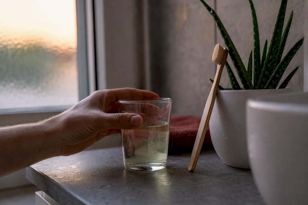 Hand reaching for water bottle by bedside
