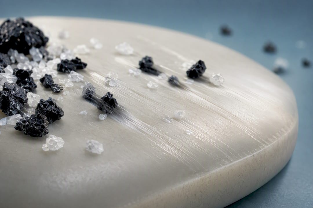 Illustration of abrasive particles wearing enamel