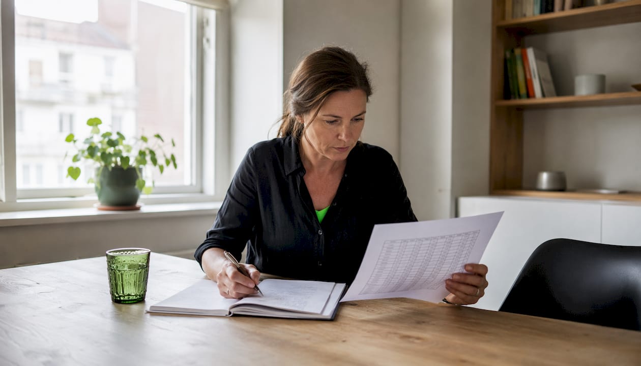 Detaljerad närbild på händer som går igenom ekonomiska rapporter och siffror