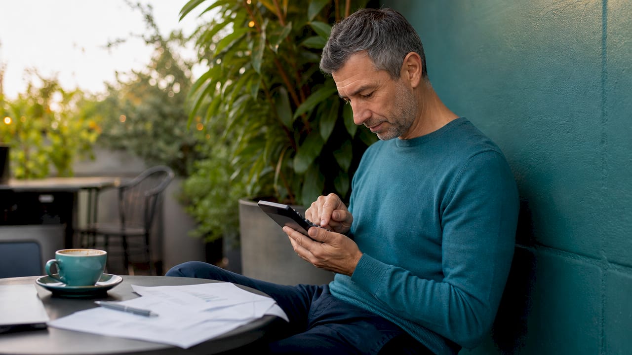 Investor calculating mortgage limits in café