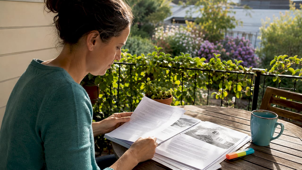 Buyer reviewing building inspection report at kitchen table