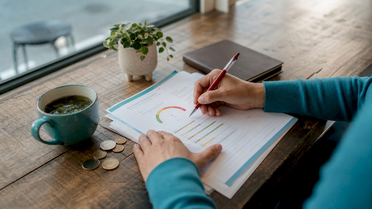 Hands reviewing credit report with red pen
