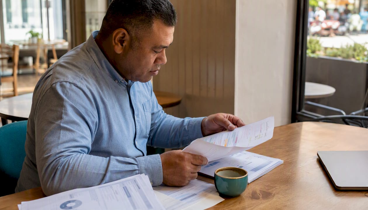 Hands reviewing credit file in NZ office