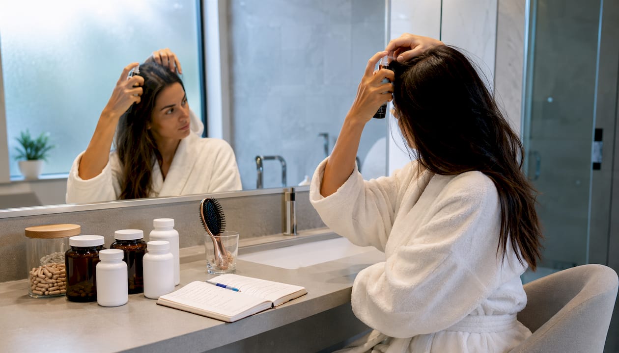 Mâini care aranjează produse pentru îngrijirea părului