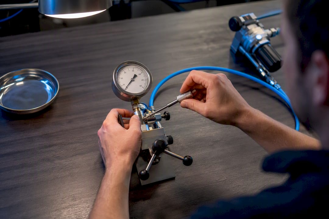 Technik kalibruje manometr před revizí