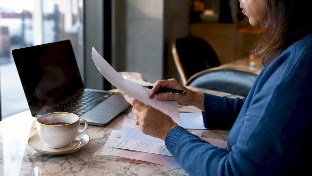 Mani che consultano un consulente finanziario e fanno i conti con la calcolatrice