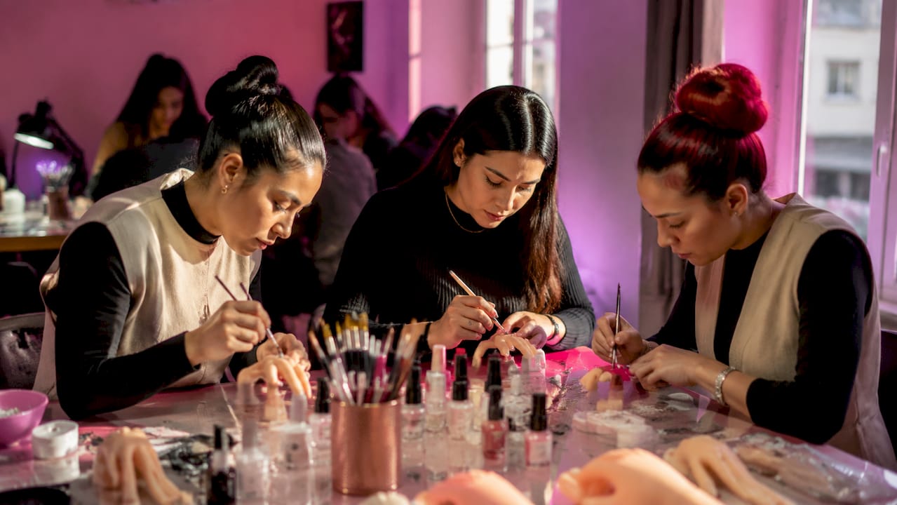 Mani che si esercitano nella nail art su dita in silicone