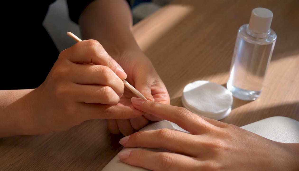 Un’estetista si prende cura delle cuticole prima di eseguire una manicure con gel.
