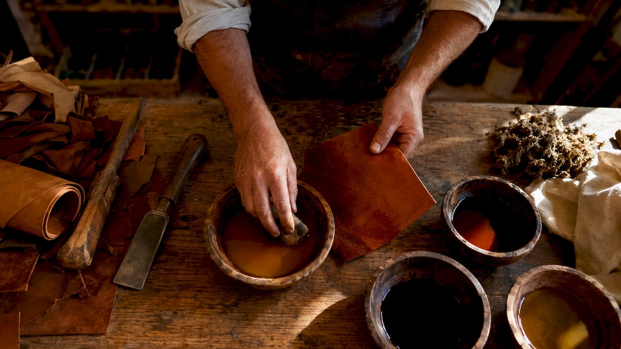 Hands vegetable tanning leather in workshop