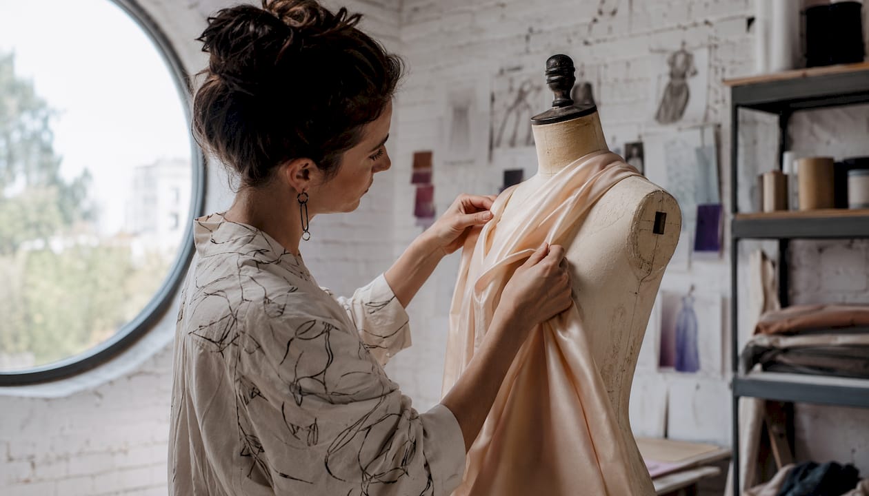 Fashion designer draping fabric on mannequin