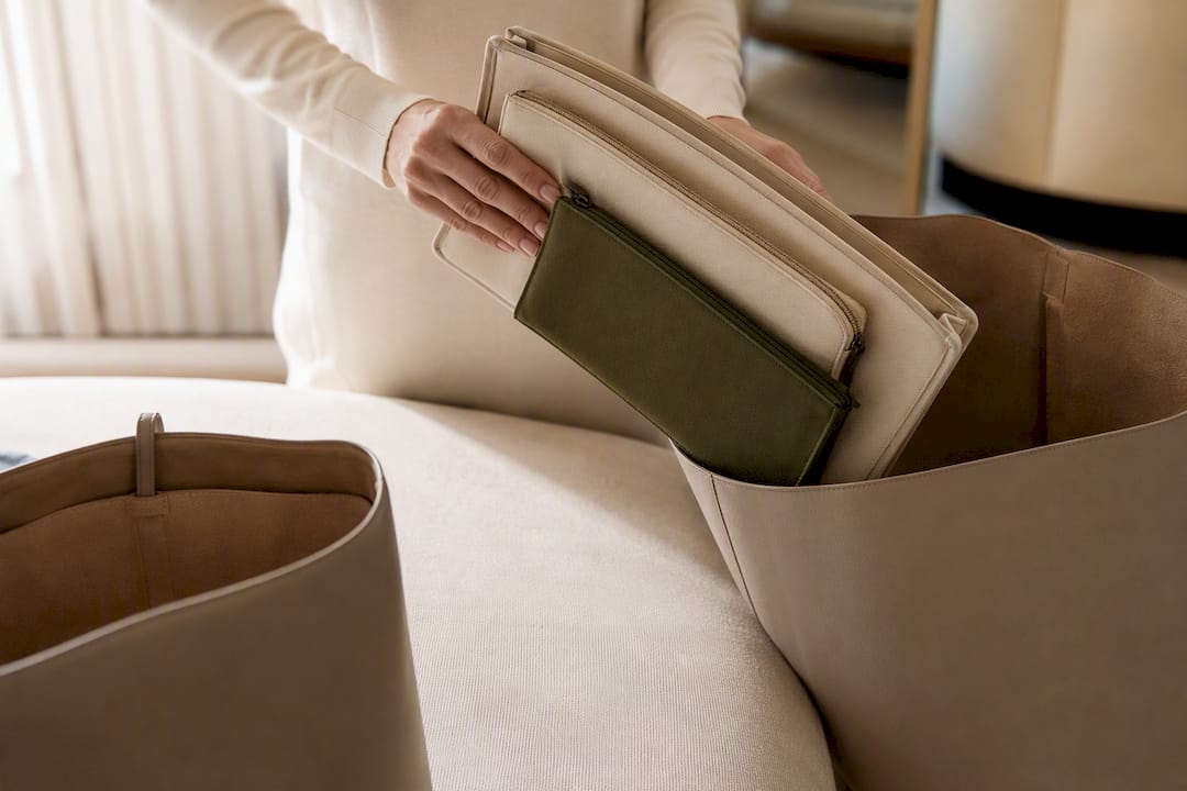 Hands transferring pouches between tote bags