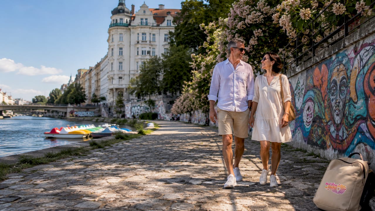 Couple walking along Danube in Vienna cityscape