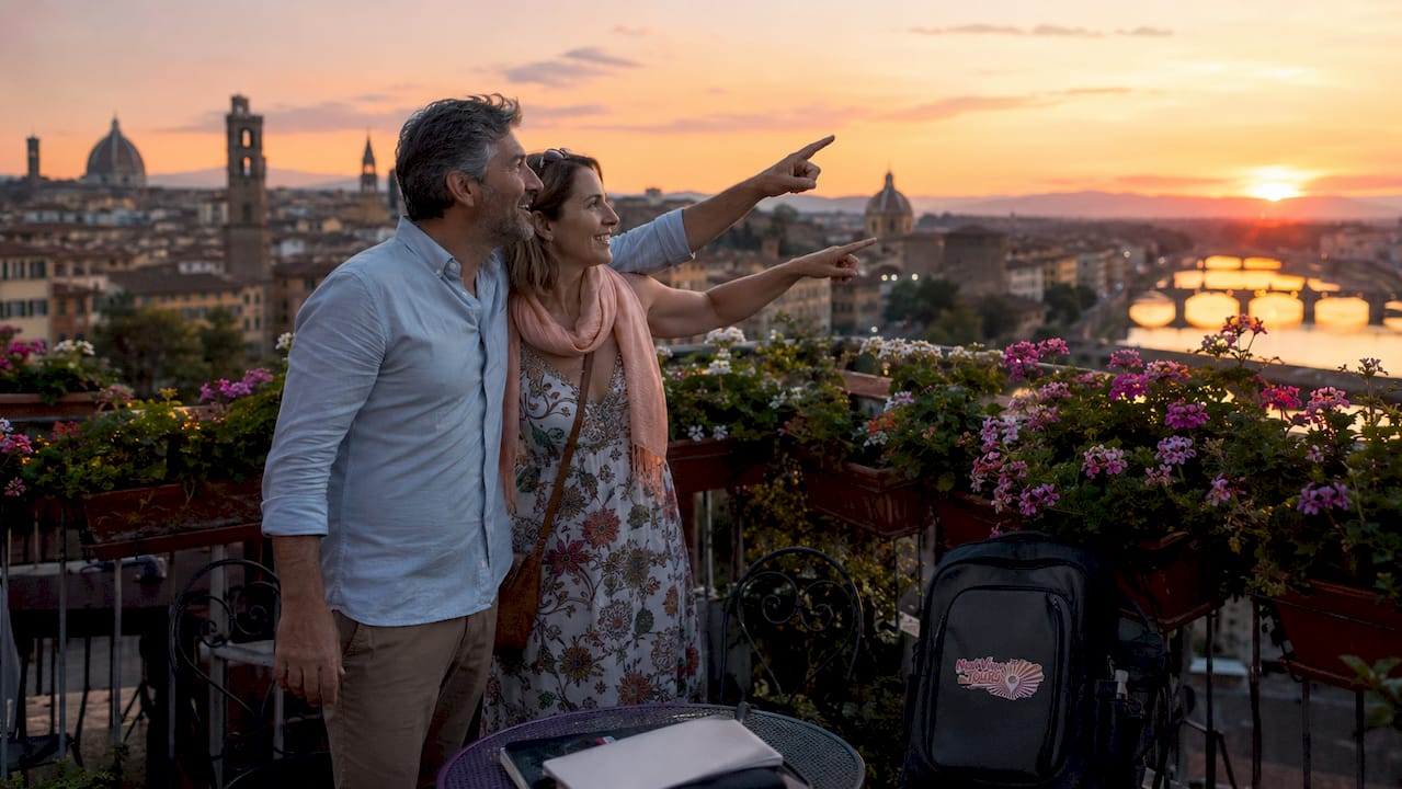 Couple spotting landmarks in European city plaza at sunset